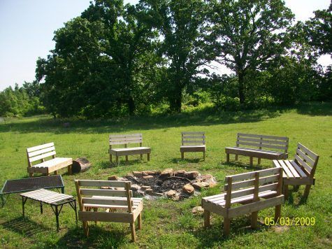 A group of wooden benches are sitting around a fire pit