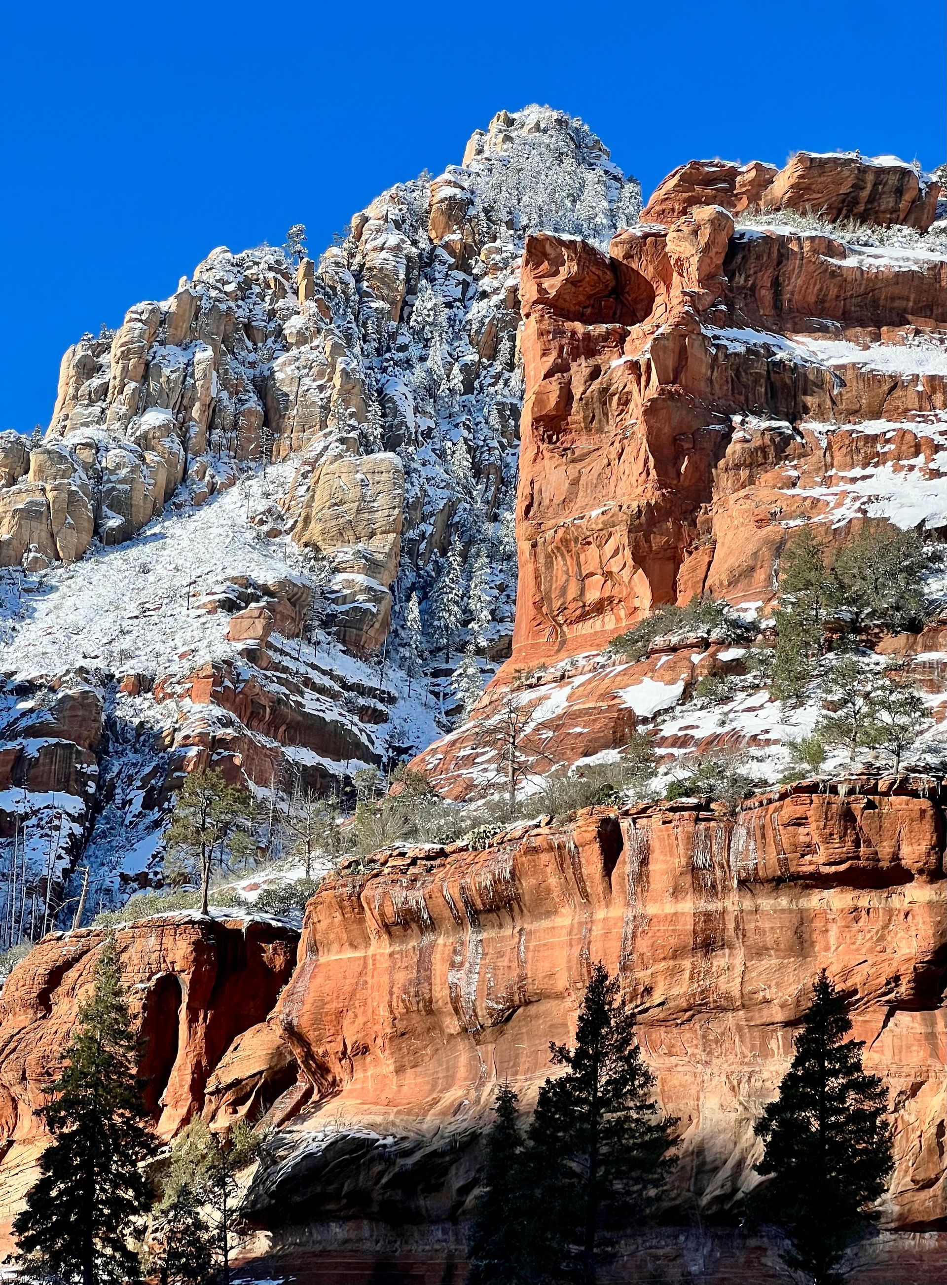 Red rock formations with snow-capped peaks under a clear blue sky. Sedona Arizona