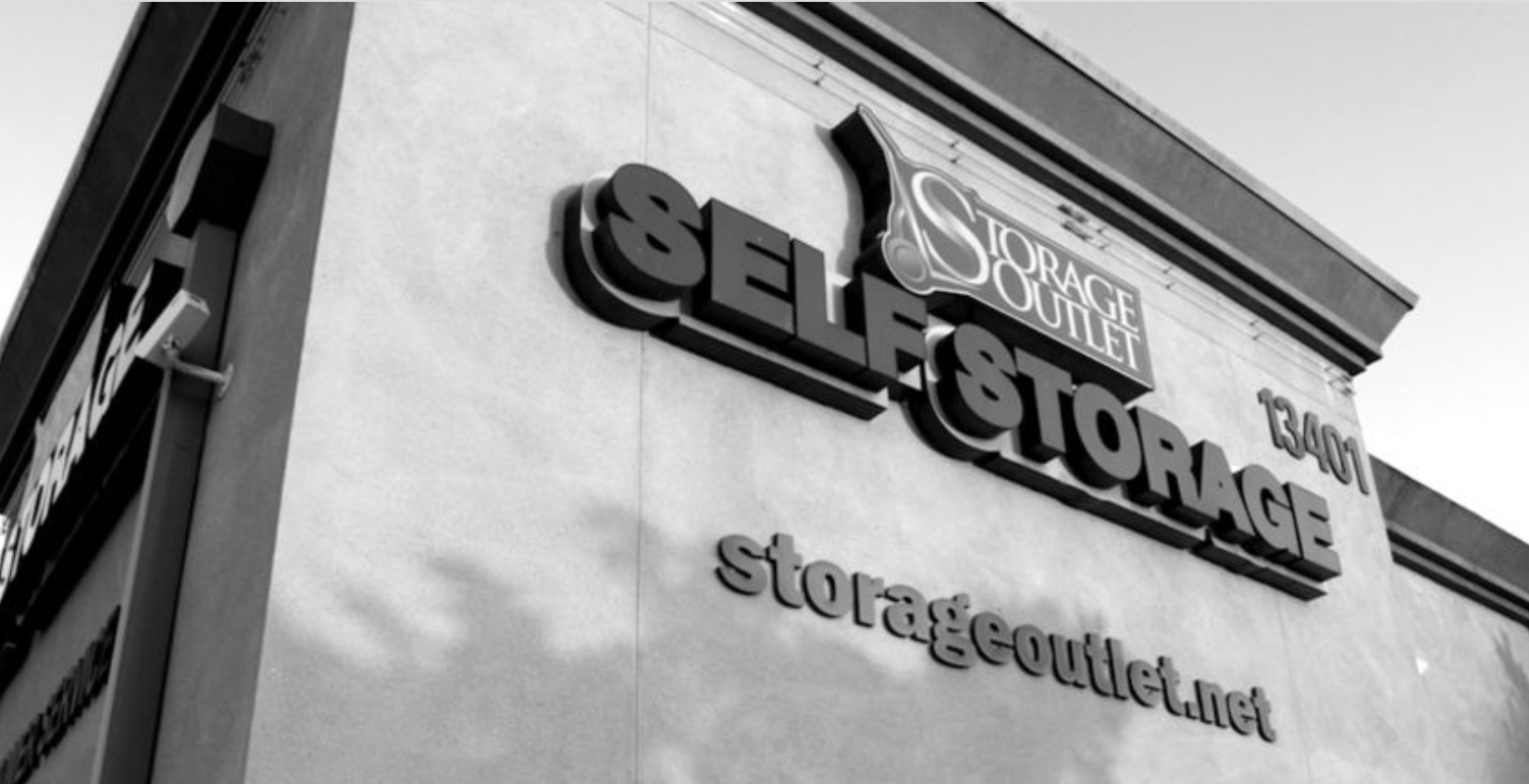Black-and-white exterior of a Select Storage storefront sign on a building.