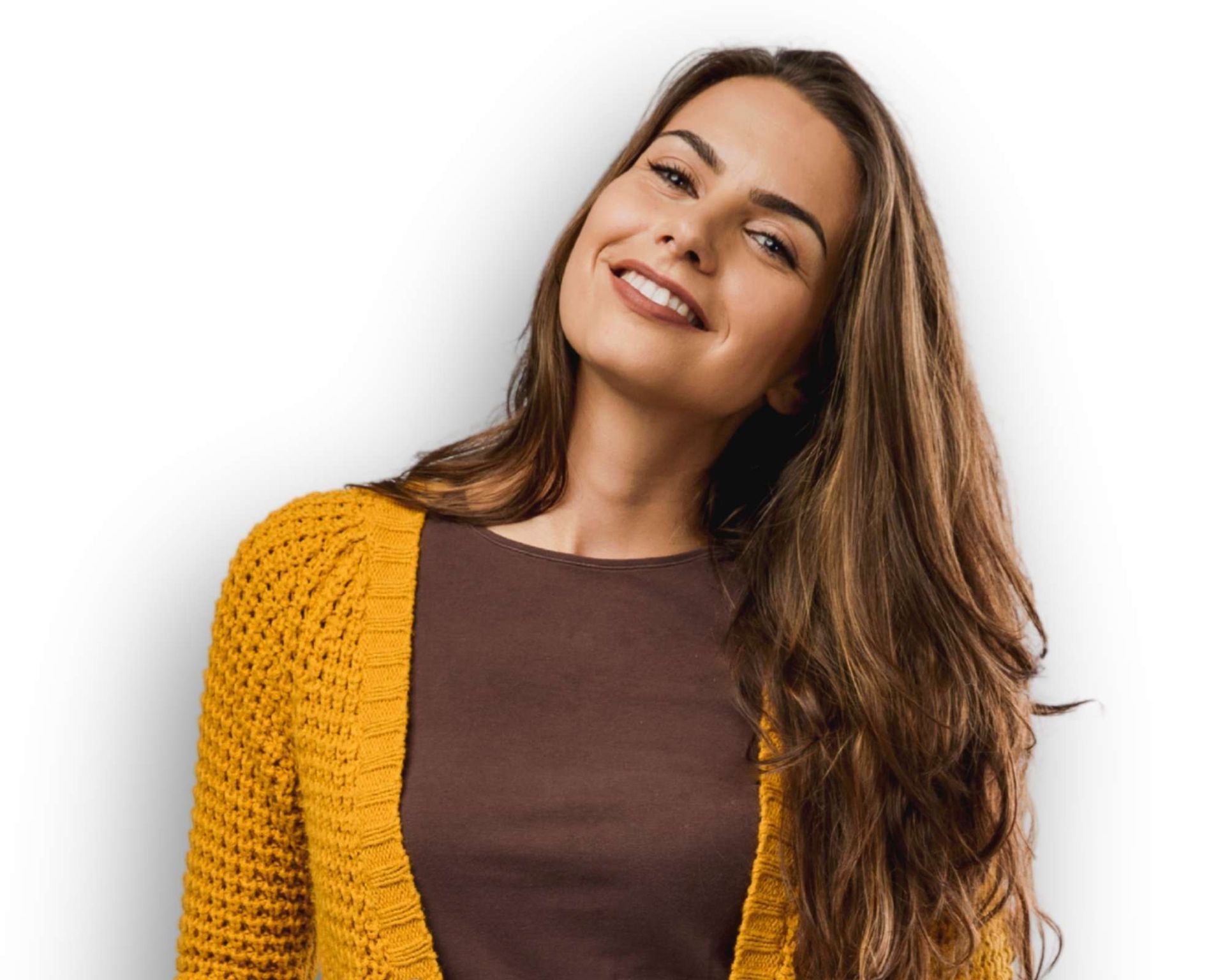 Mulher com longos cabelos castanhos sorri, vestindo um cardigã amarelo e uma blusa marrom.