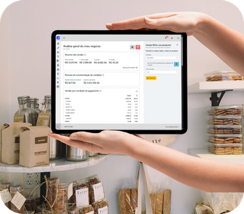 Uma pessoa está segurando um tablet em frente a uma prateleira de comida.