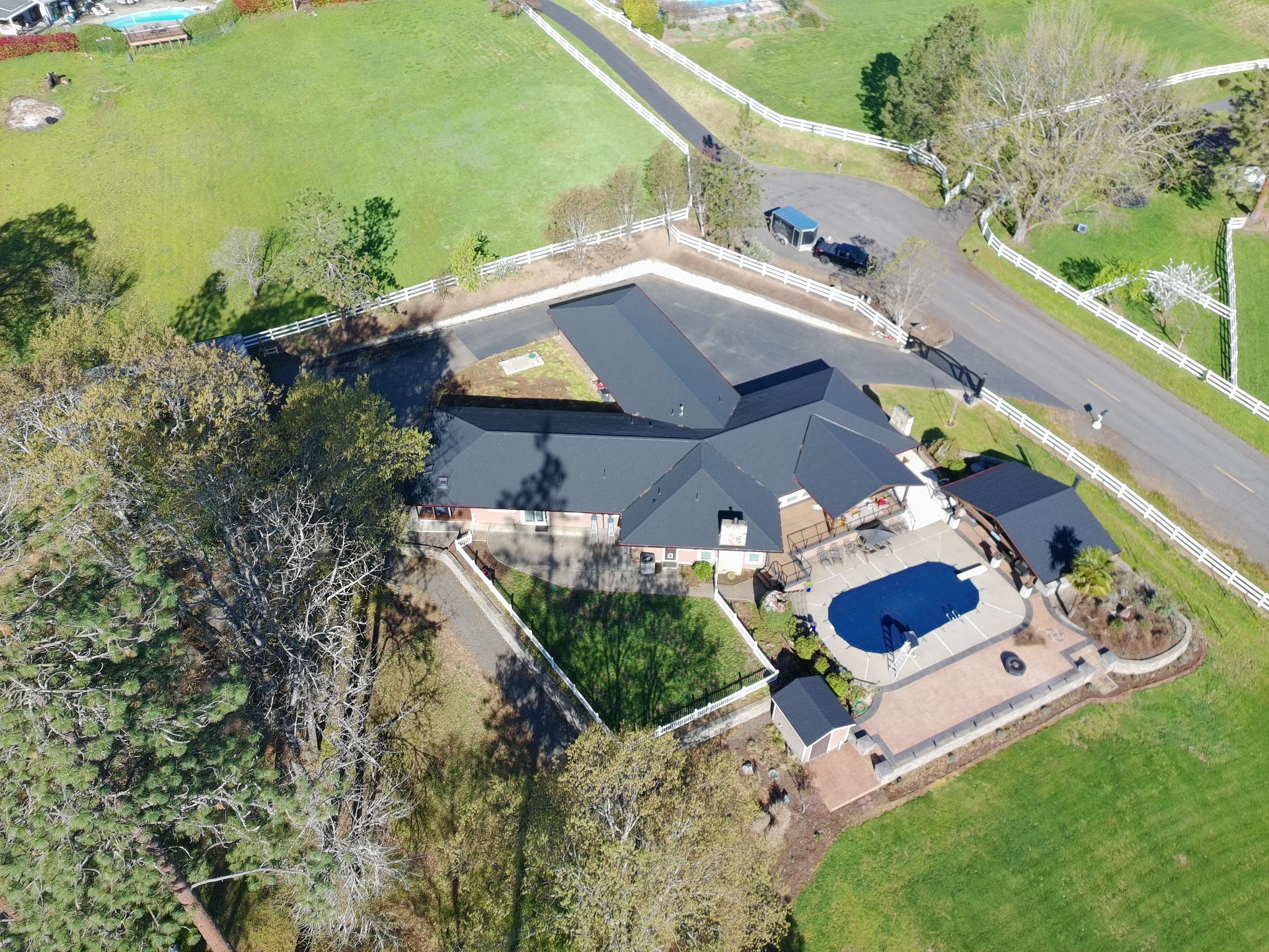 Aerial view of a completed dark asphalt shingle roof by Straight Forward Construction