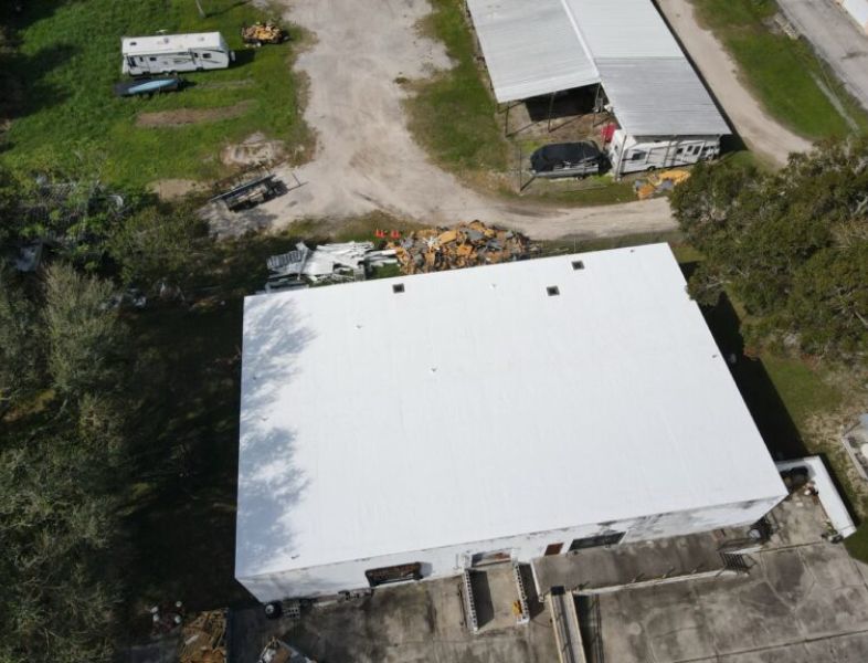 Overhead aerial view of a white low-slope roof on a rural commercial structure
