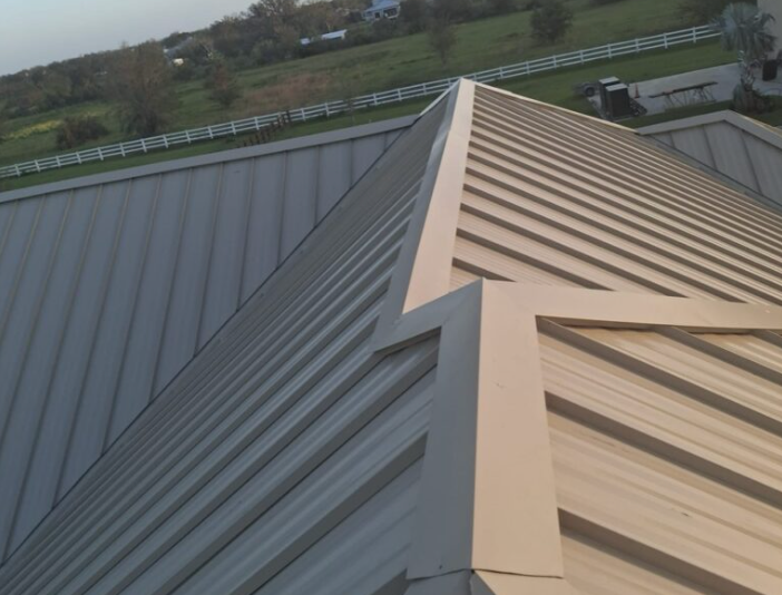 Close aerial view of metal roof panels meeting at a hip and valley