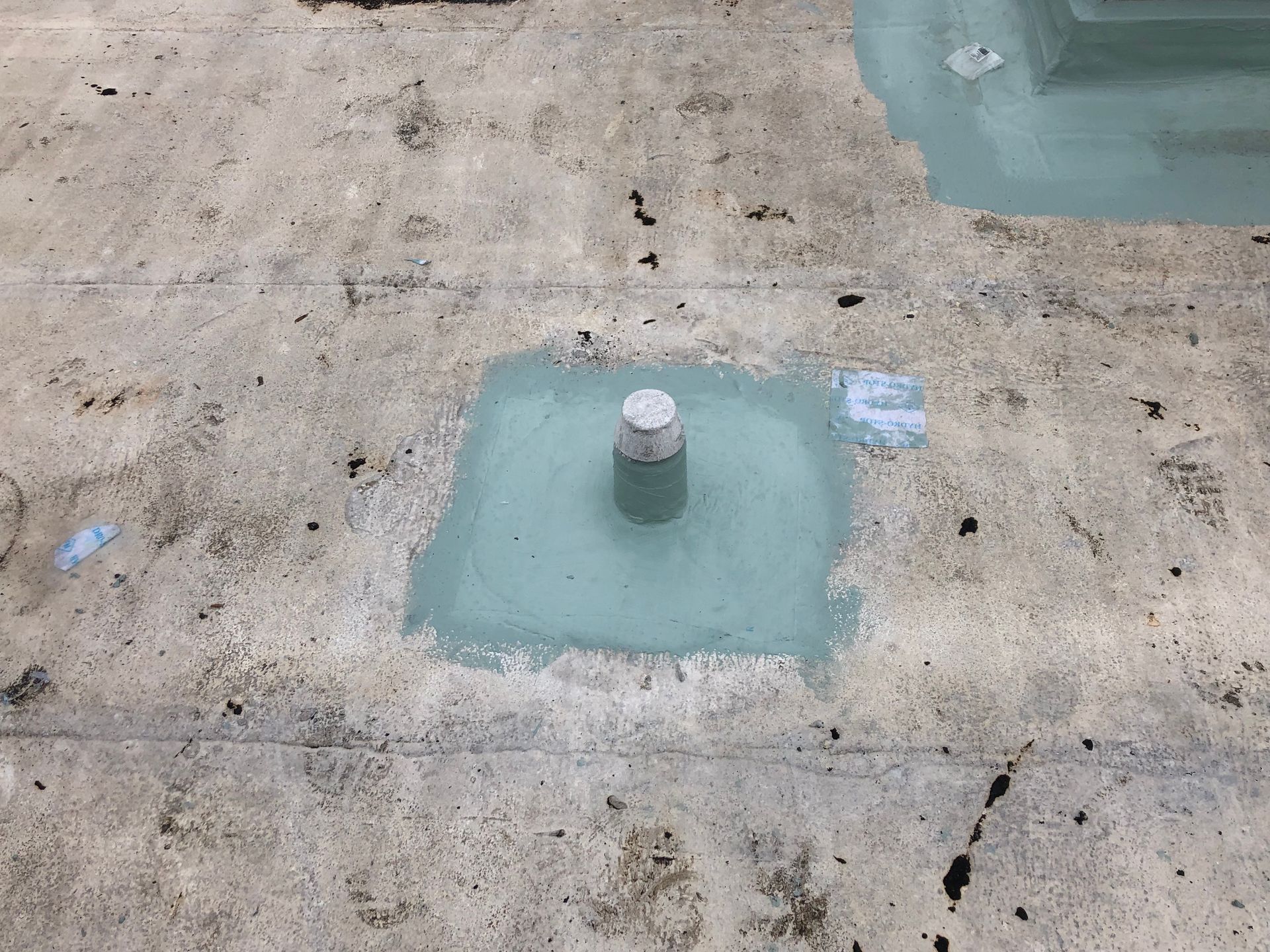 Commercial roofer inspecting drains and penetrations during maintenance in Auburndale, Florida