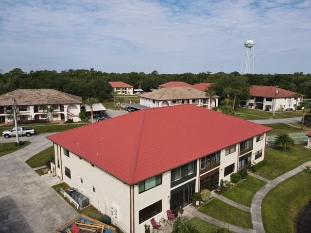 Completed red metal roof on a multi-story commercial or multi-family building