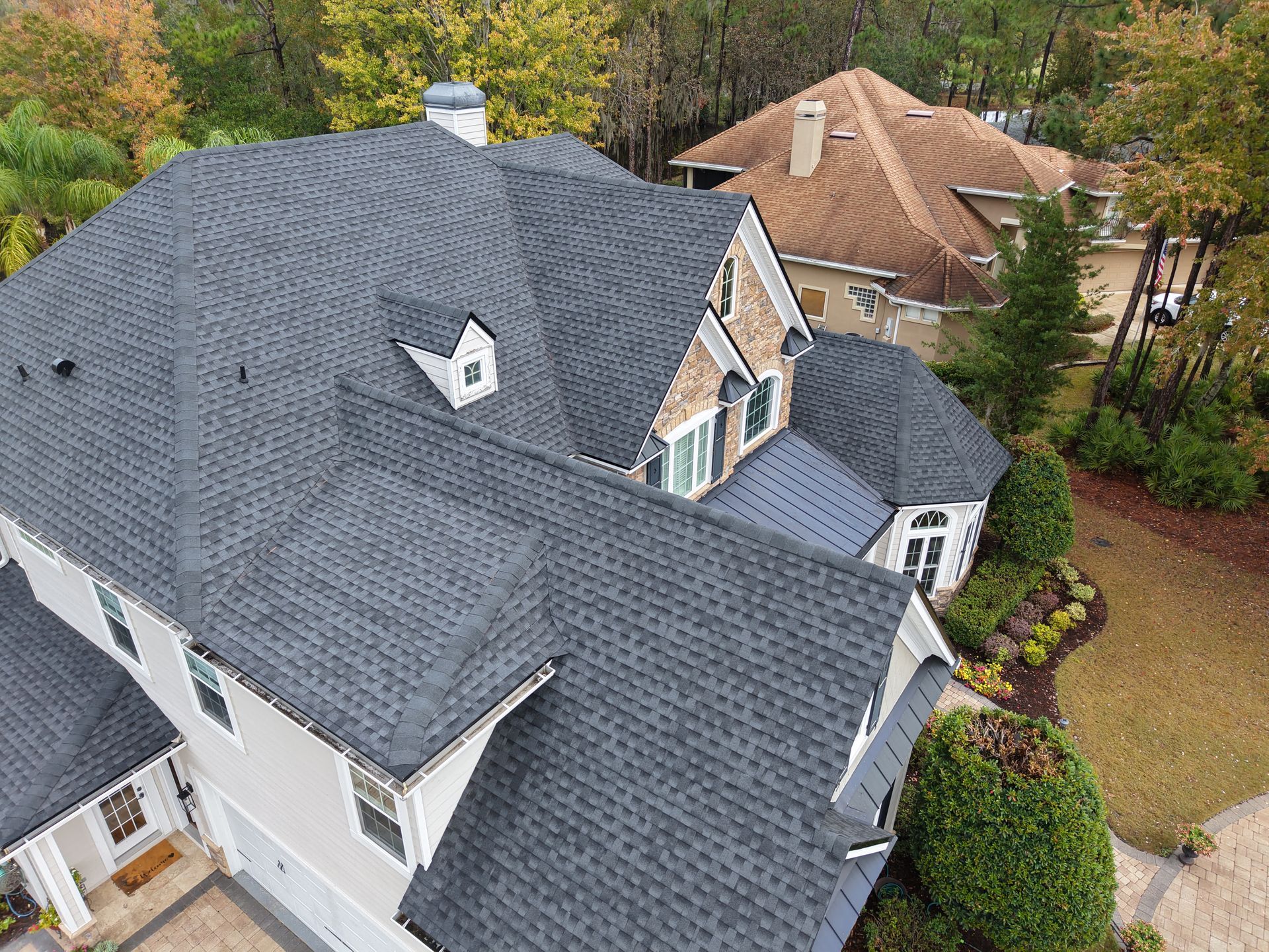 Roofer inspecting asphalt shingles and flashing on an Auburndale, Florida home