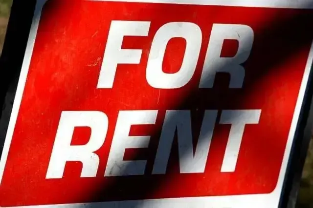 Red and white FOR RENT sign on a black background