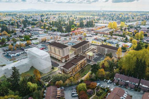 Aerial view of a suburban neighborhood with apartment buildings, trees, and parking lots in autumn.