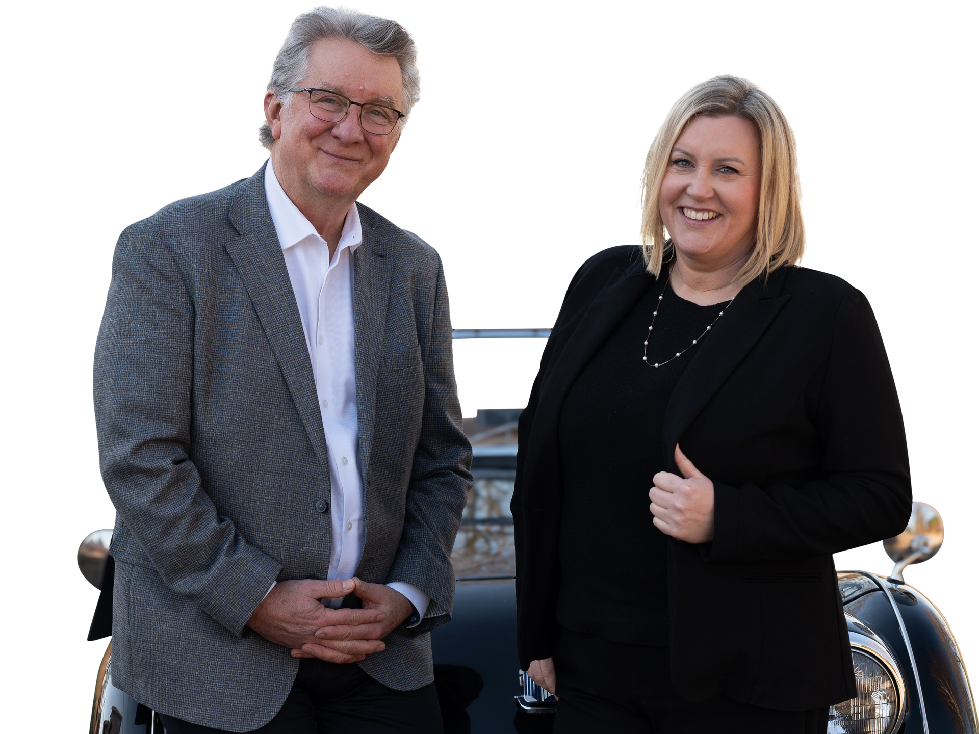 Two people standing in front of a car, smiling at the camera
