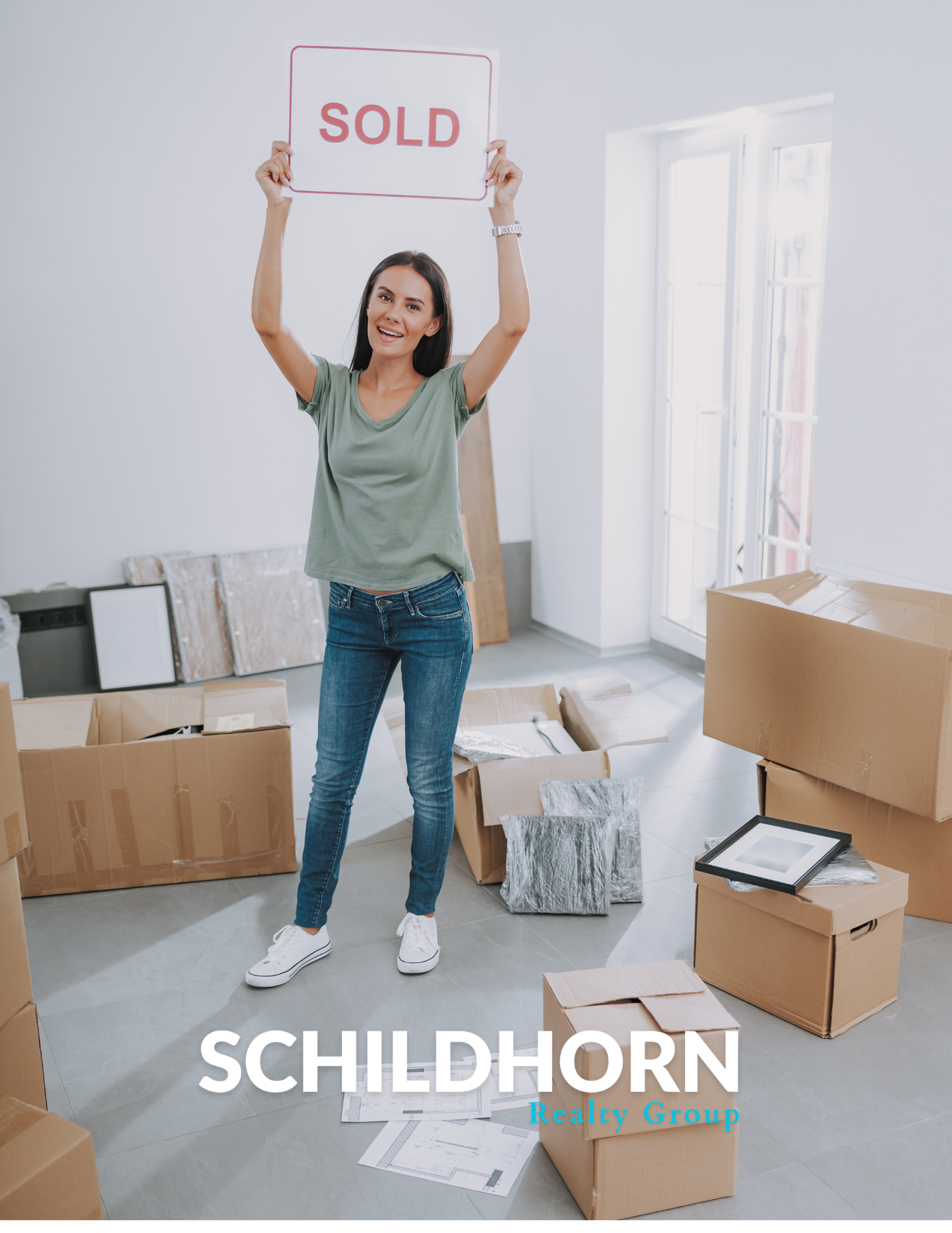 Woman holding “SOLD” sign in a bright room with moving boxes and “SCHILDHORN” text