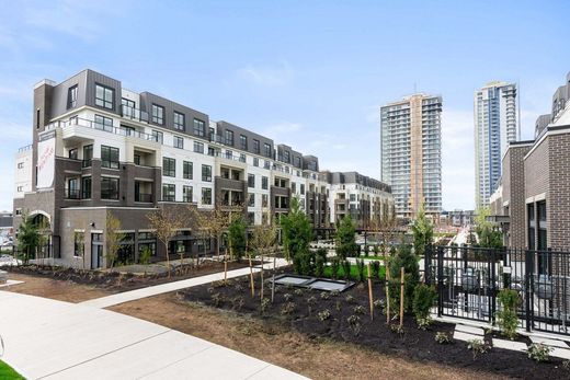 Modern apartment complex with landscaped courtyard and high-rise towers in the background