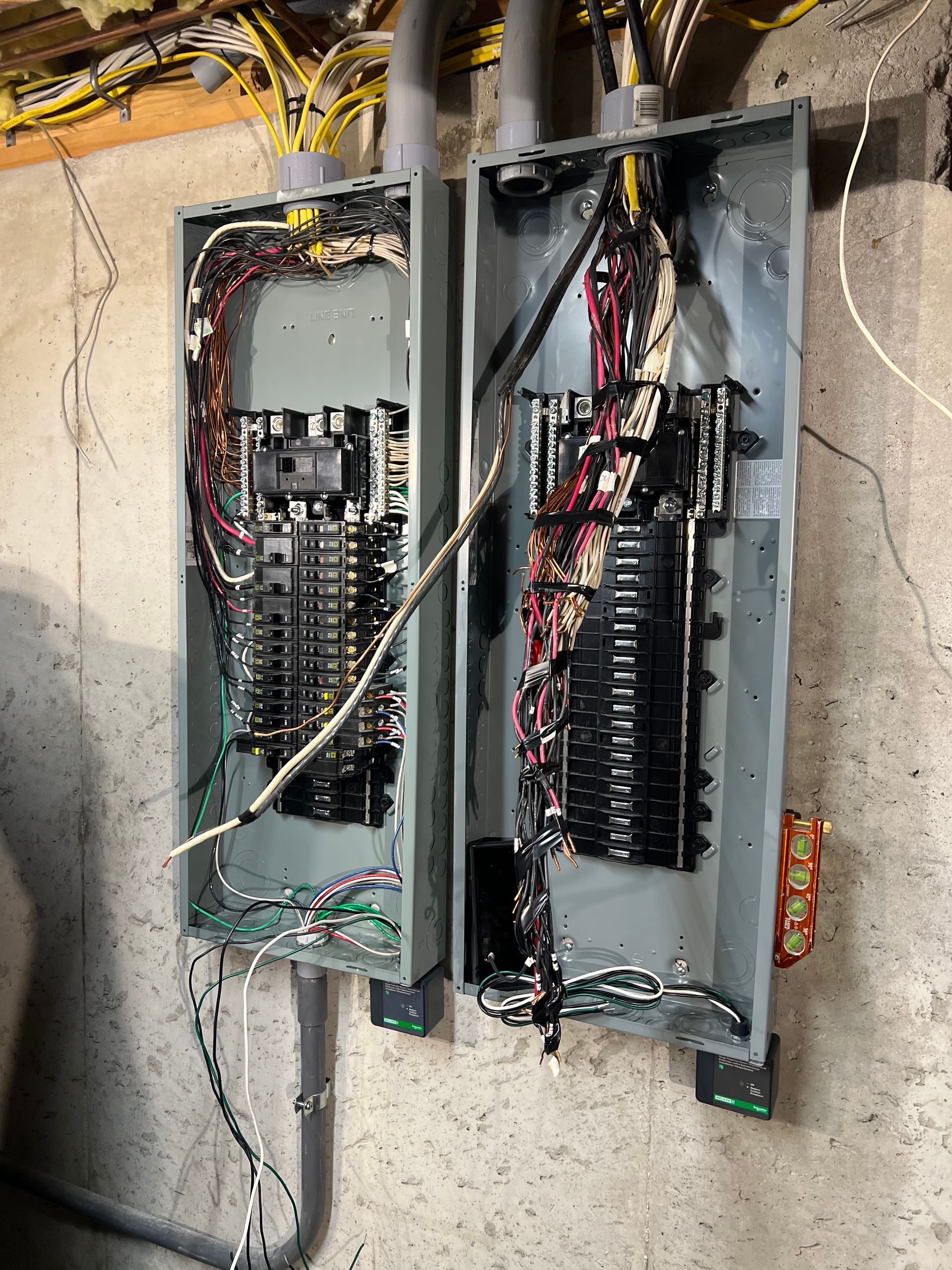 Two electrical boxes are sitting next to each other on a wall.