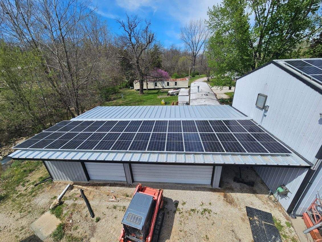 An aerial view of a house with solar panels on the roof.