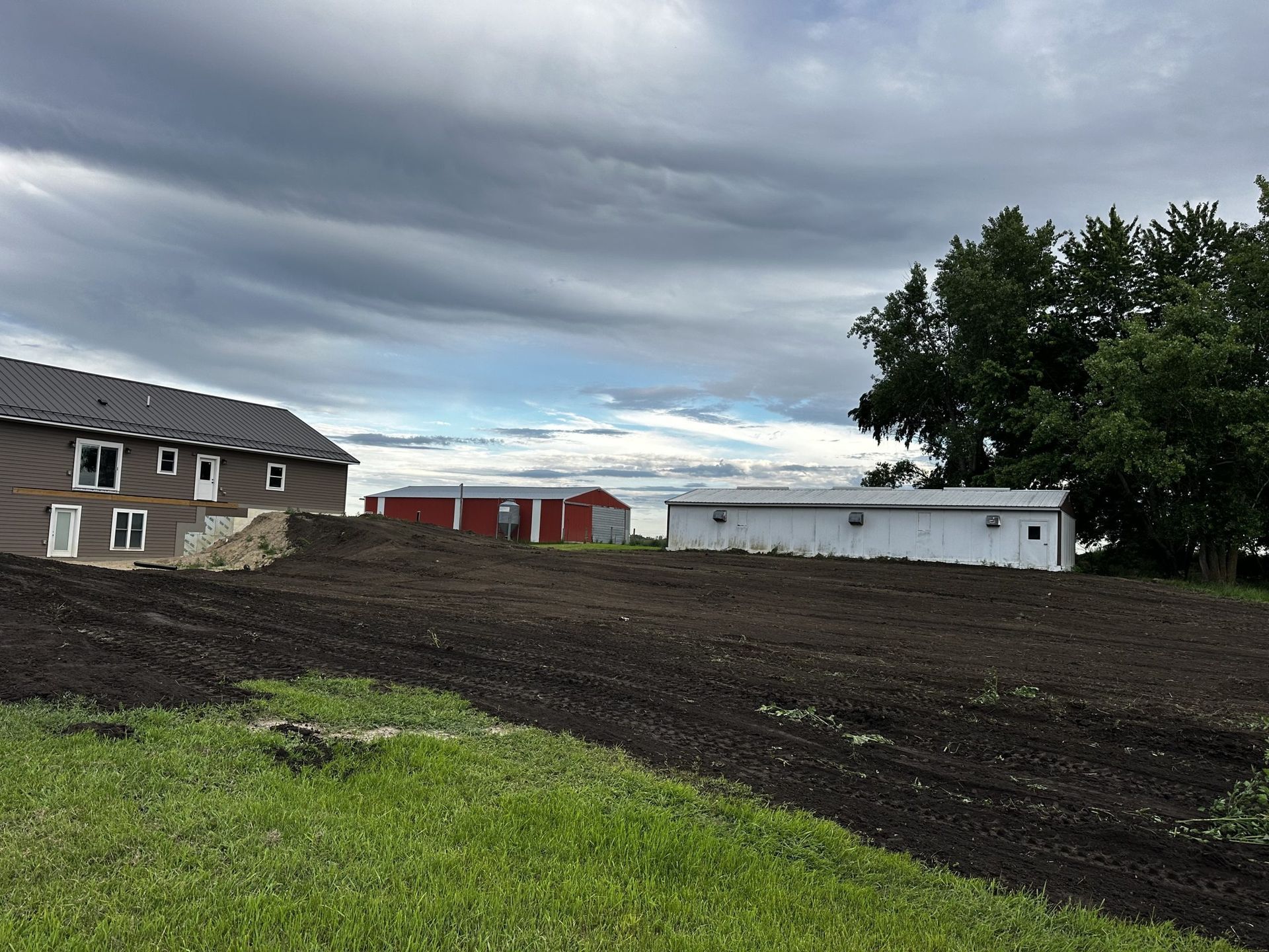 New houses on a muddy construction site under a cloudy sky