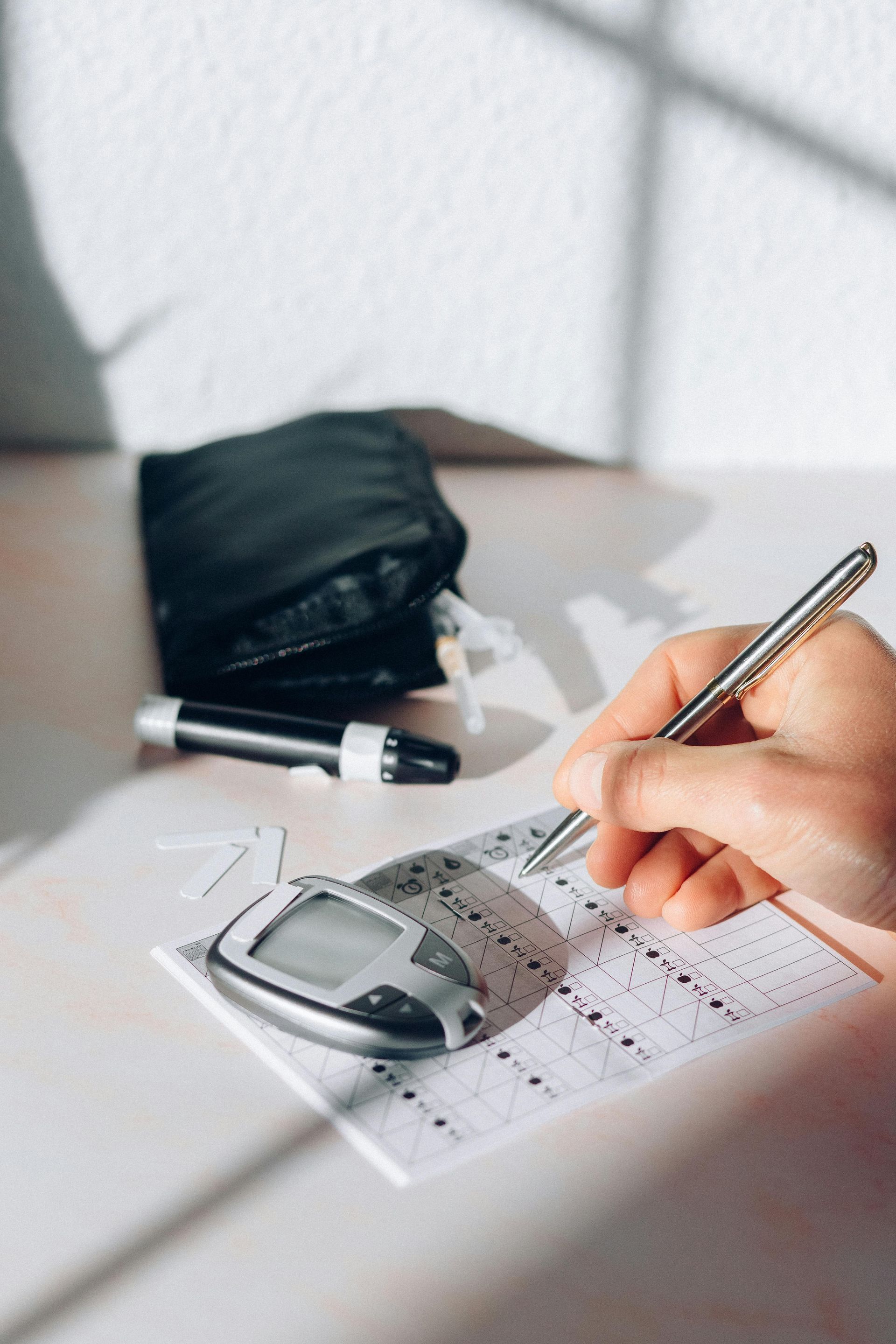 A person is writing on a piece of paper with a pen.