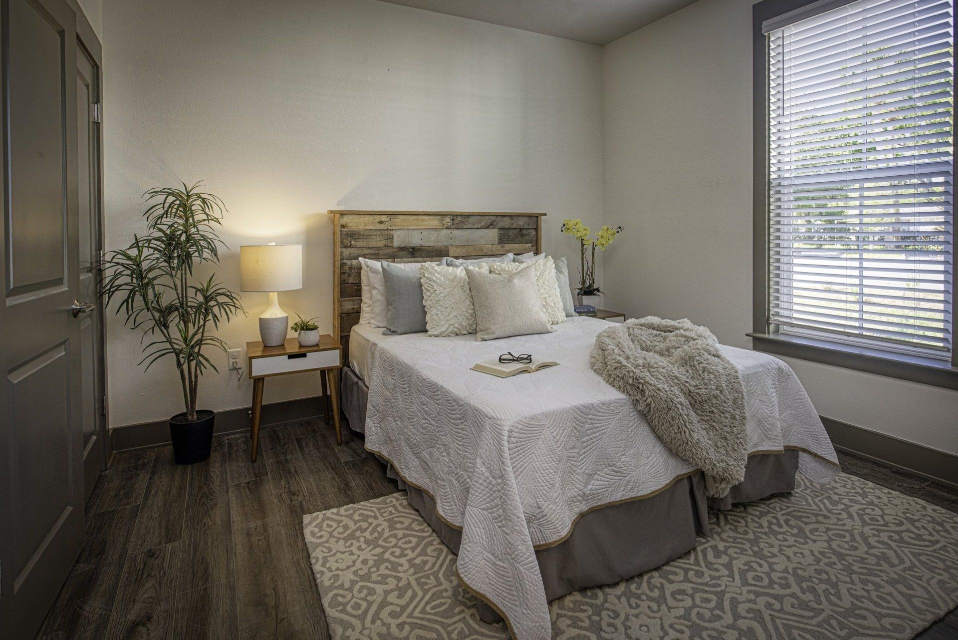 Photo showing a bedroom with wood or wood-like flooring
