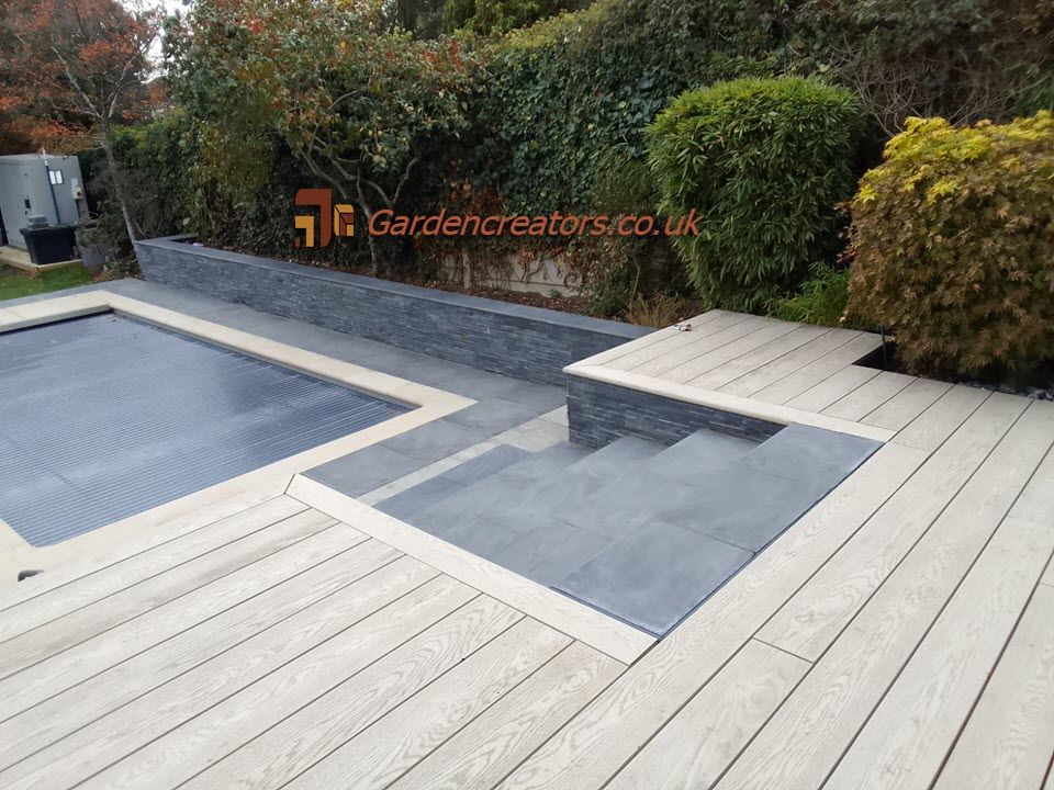 A composite deck with stairs leading to a swimming pool.