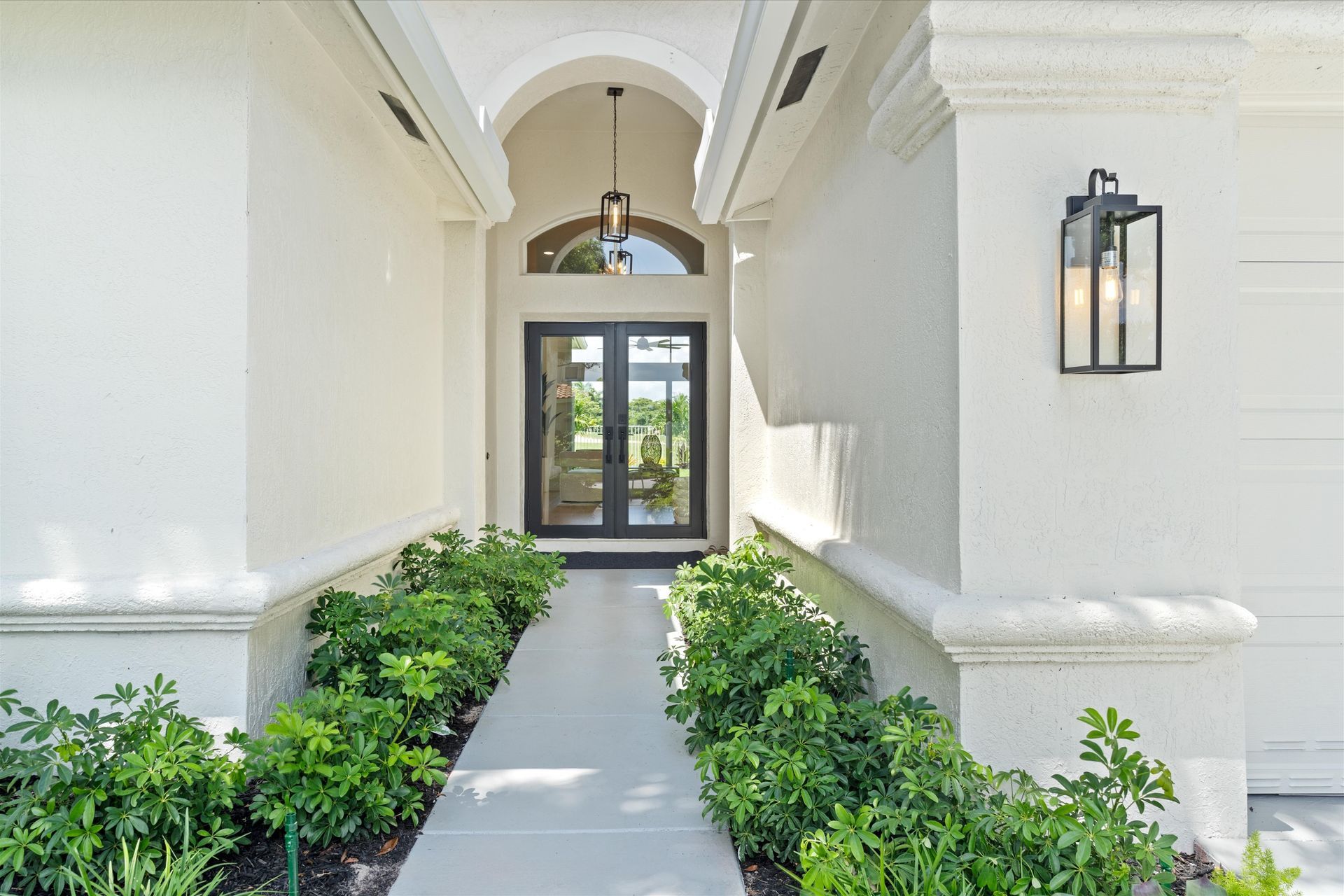 A white house with a walkway leading to the front door.