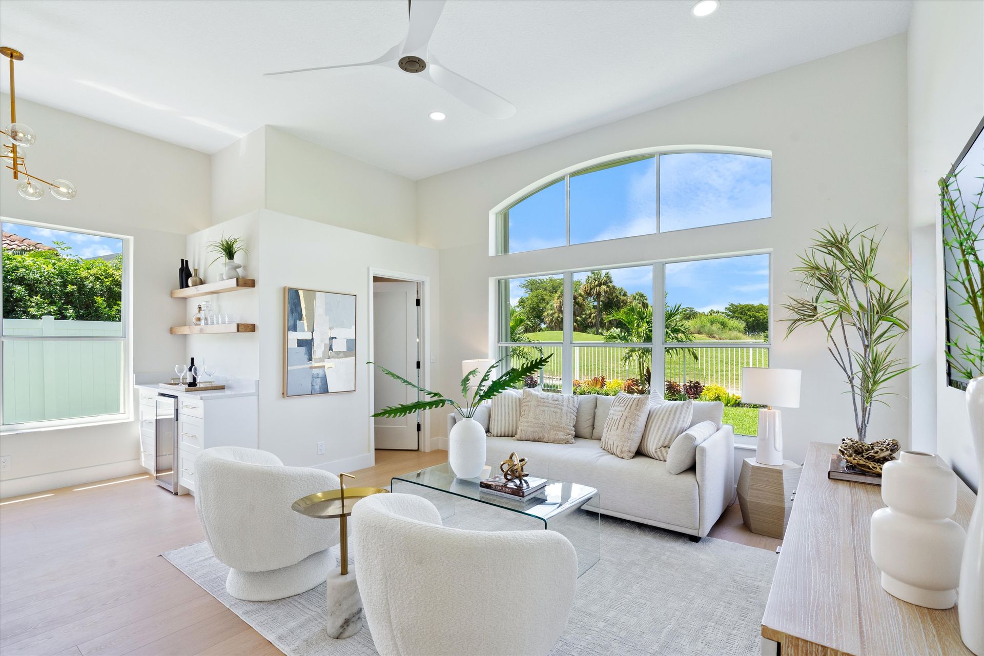A living room with a couch , chairs , a table and a ceiling fan.