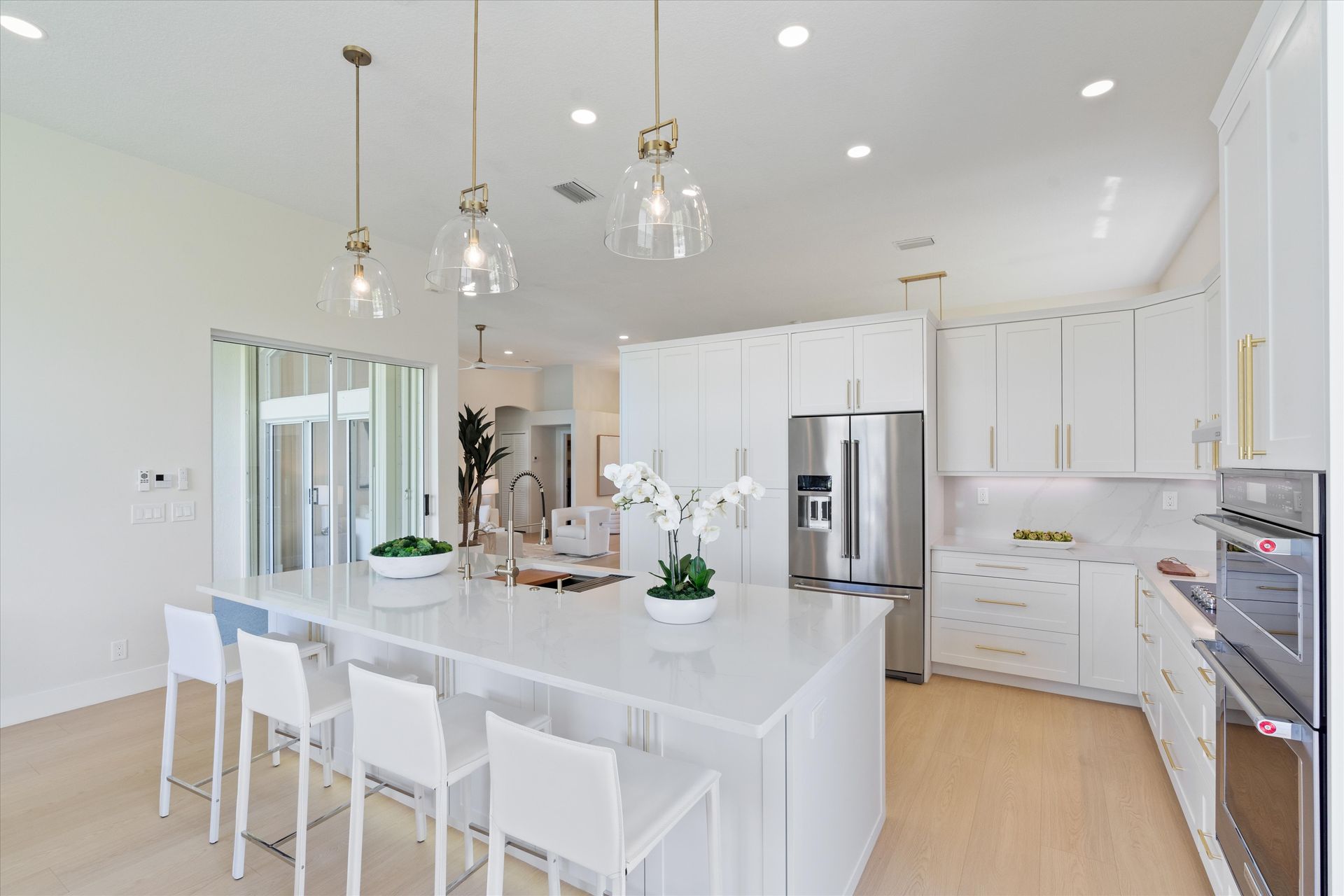 A kitchen with white cabinets and stainless steel appliances and a large island.