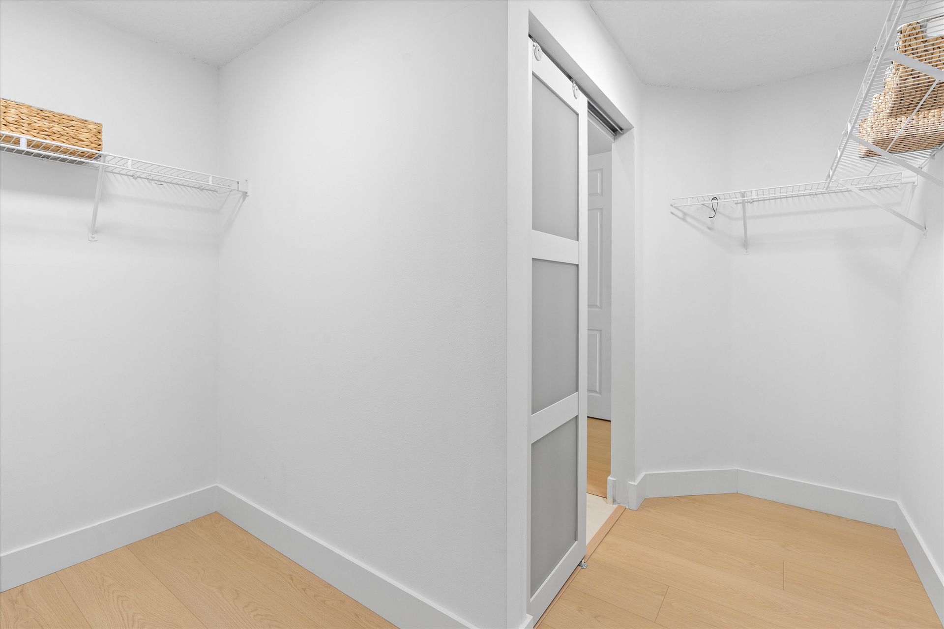A walk in closet with a sliding glass door and shelves.
