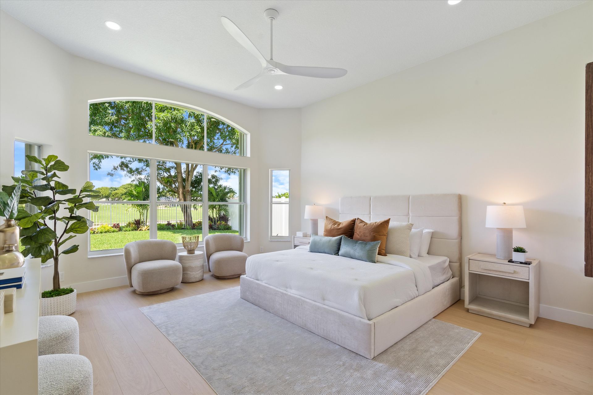 A bedroom with a large bed and a ceiling fan.