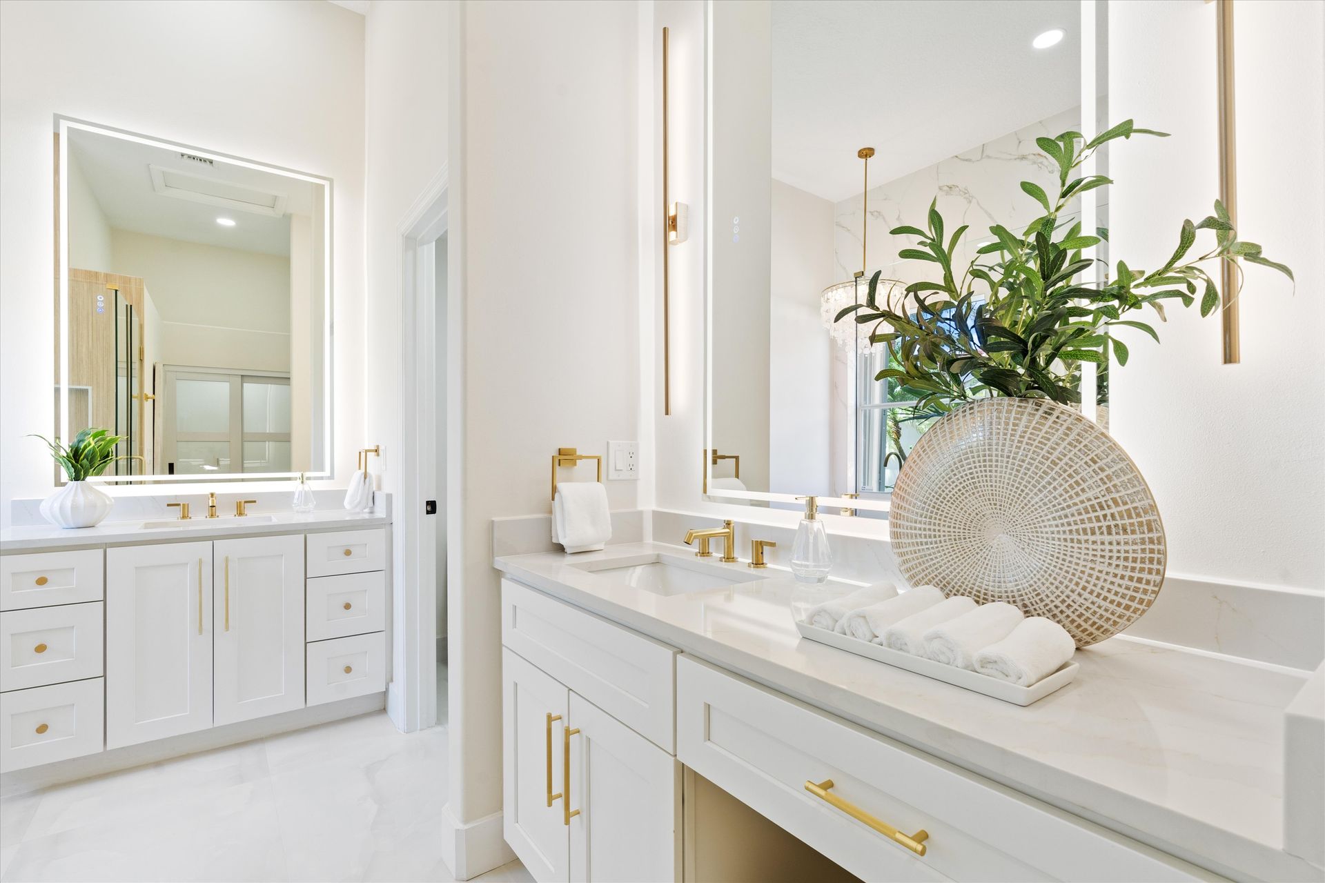 A bathroom with two sinks , a large mirror and a vase of flowers.
