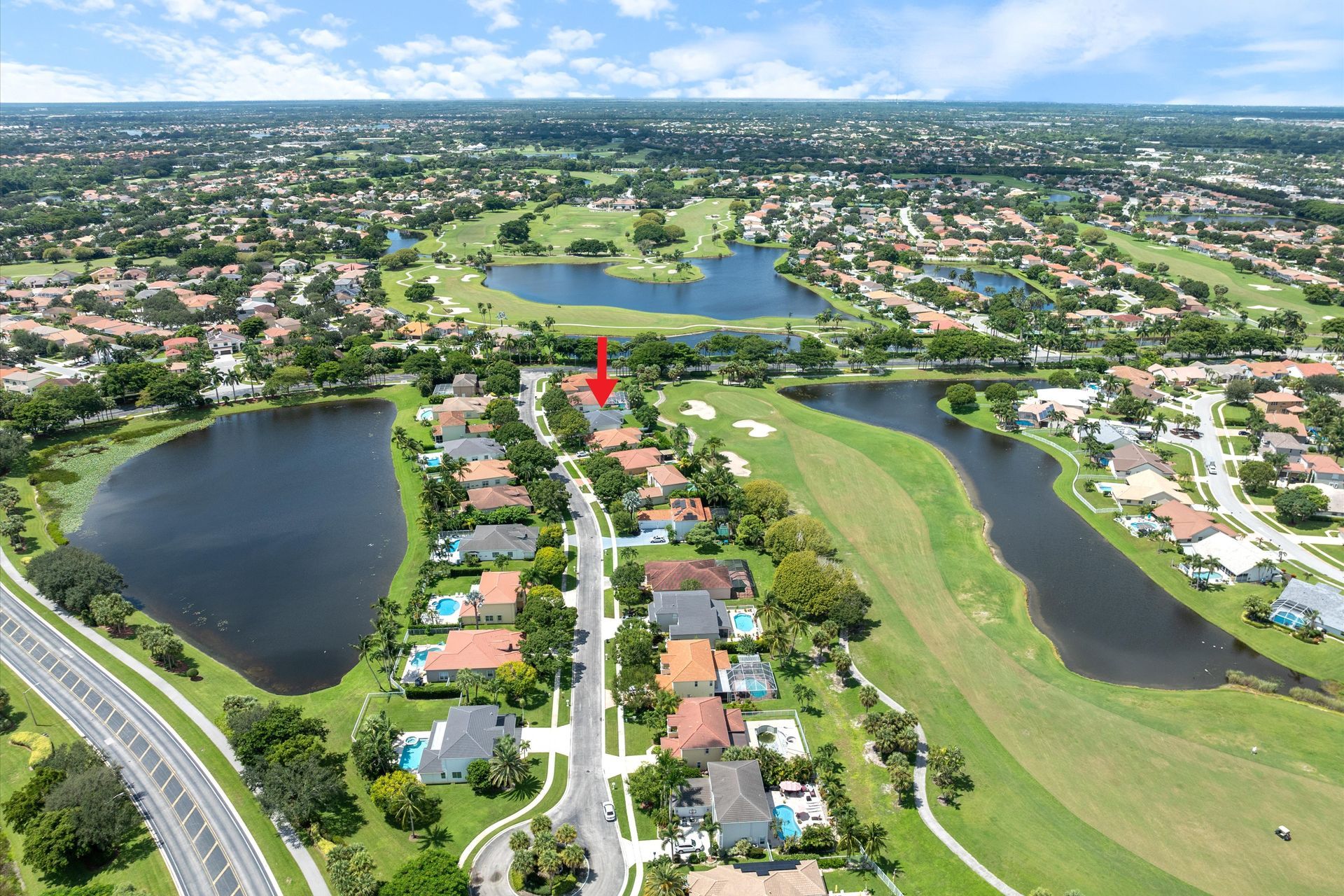 An aerial view of a residential area with a red arrow pointing to a house