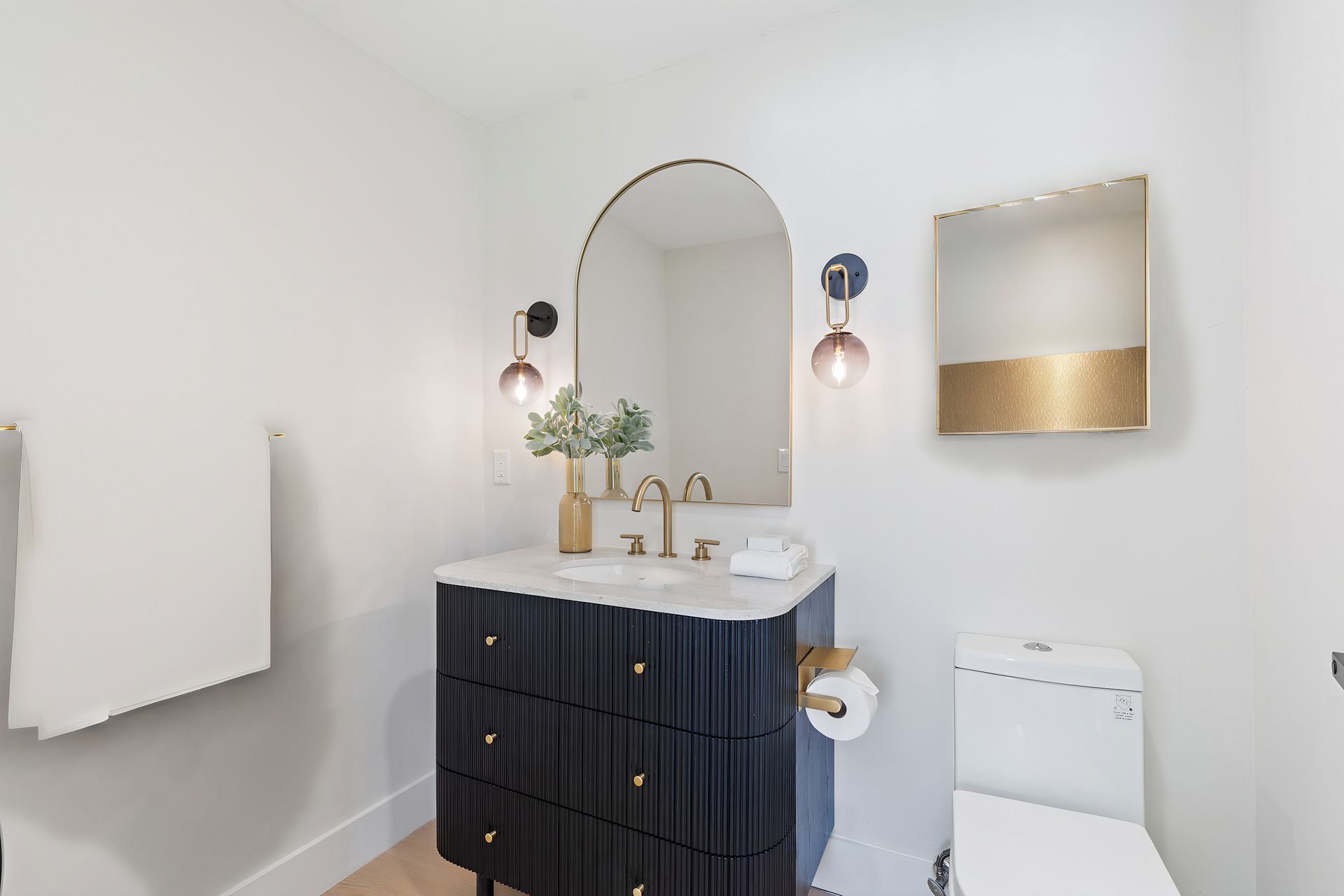 A bathroom with a sink , toilet and mirror.