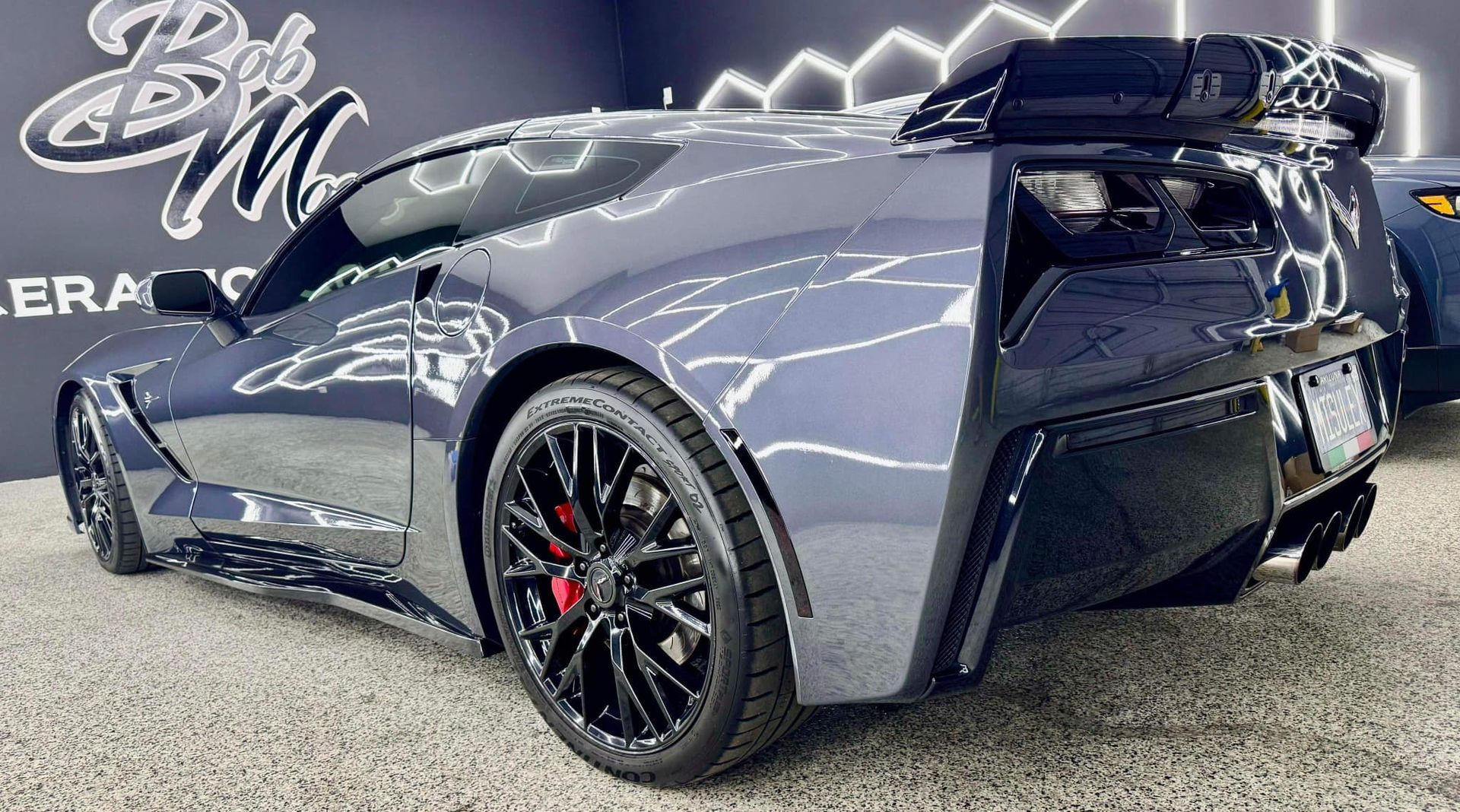 A black sports car is parked in a showroom.
