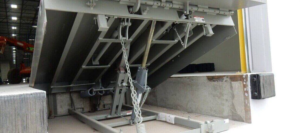 A large metal structure is sitting on top of a concrete floor in a warehouse.
