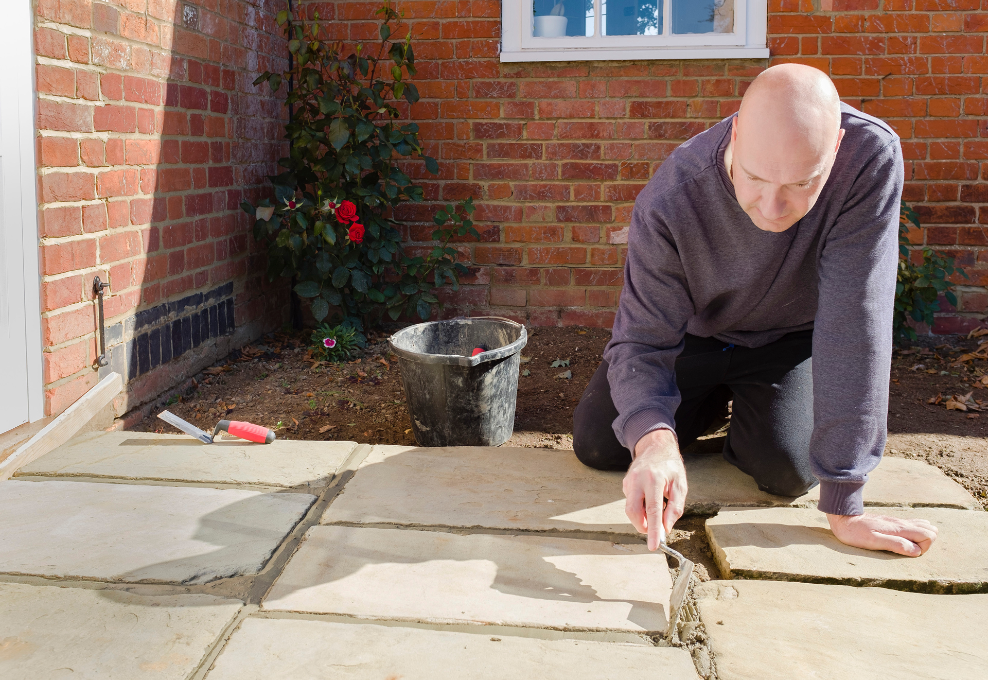 man-laying-pavers