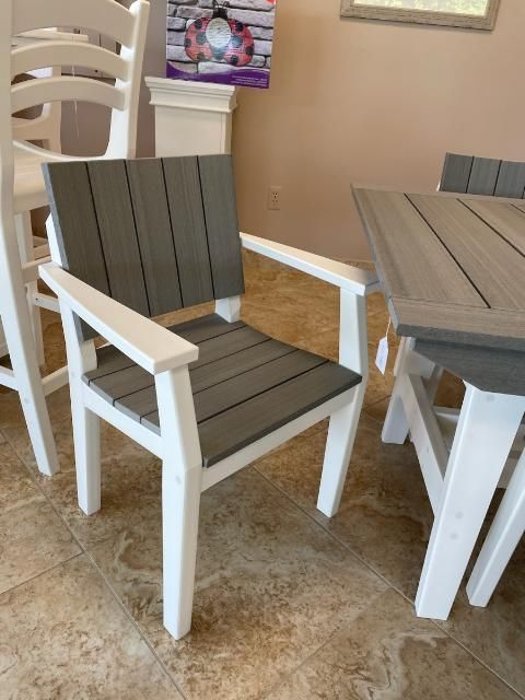 A gray and white chair sits next to a table