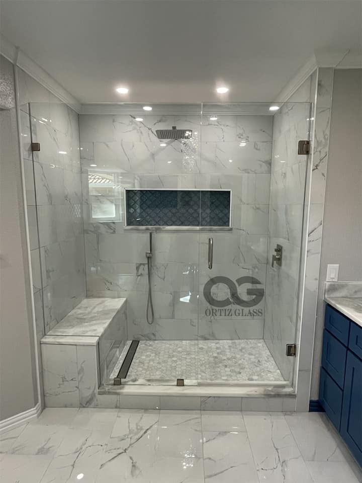 A bathroom with a walk in shower and a bench.
