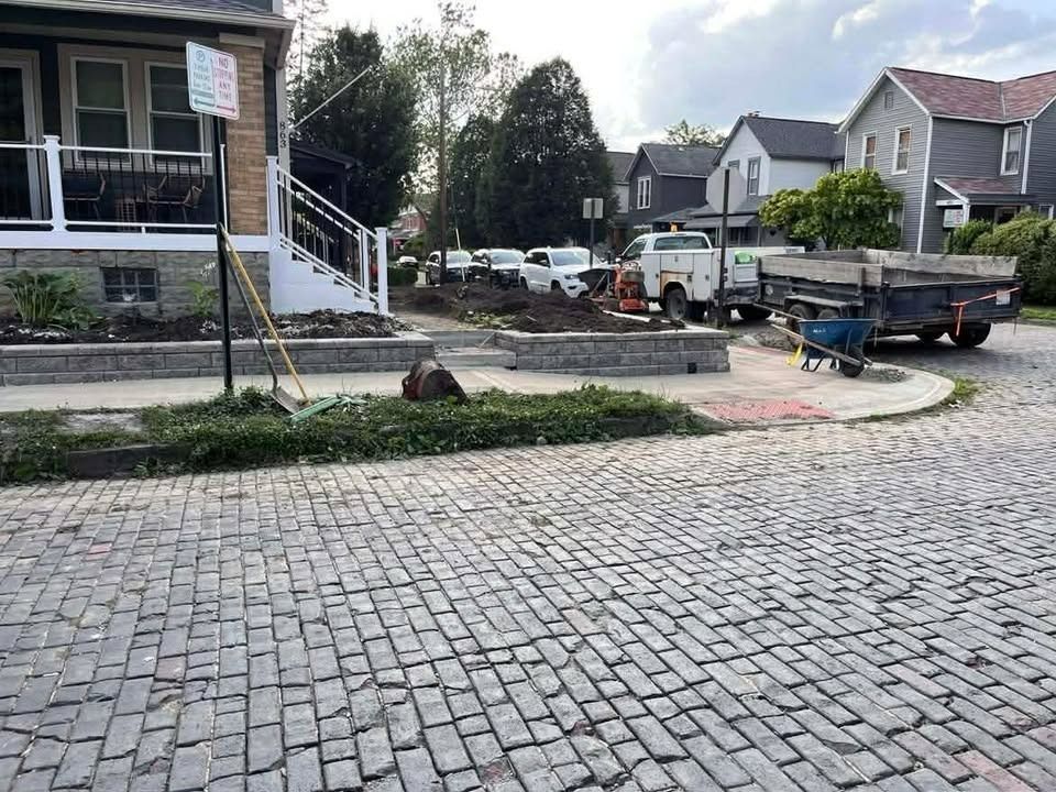 Cobblestone street with parked trucks and houses in a residential neighborhood after roadwork