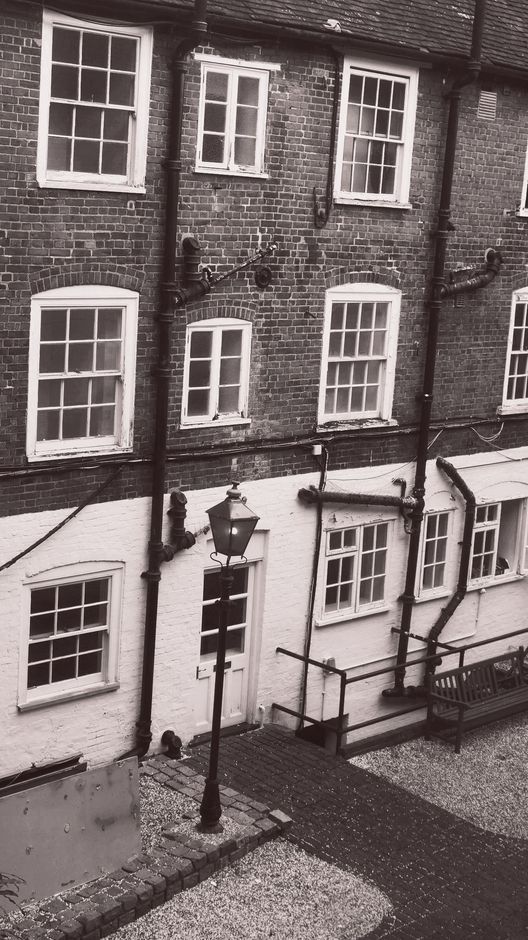 A black and white photo of a brick building with many windows