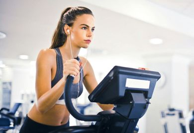 A woman is riding an exercise bike in a gym.
