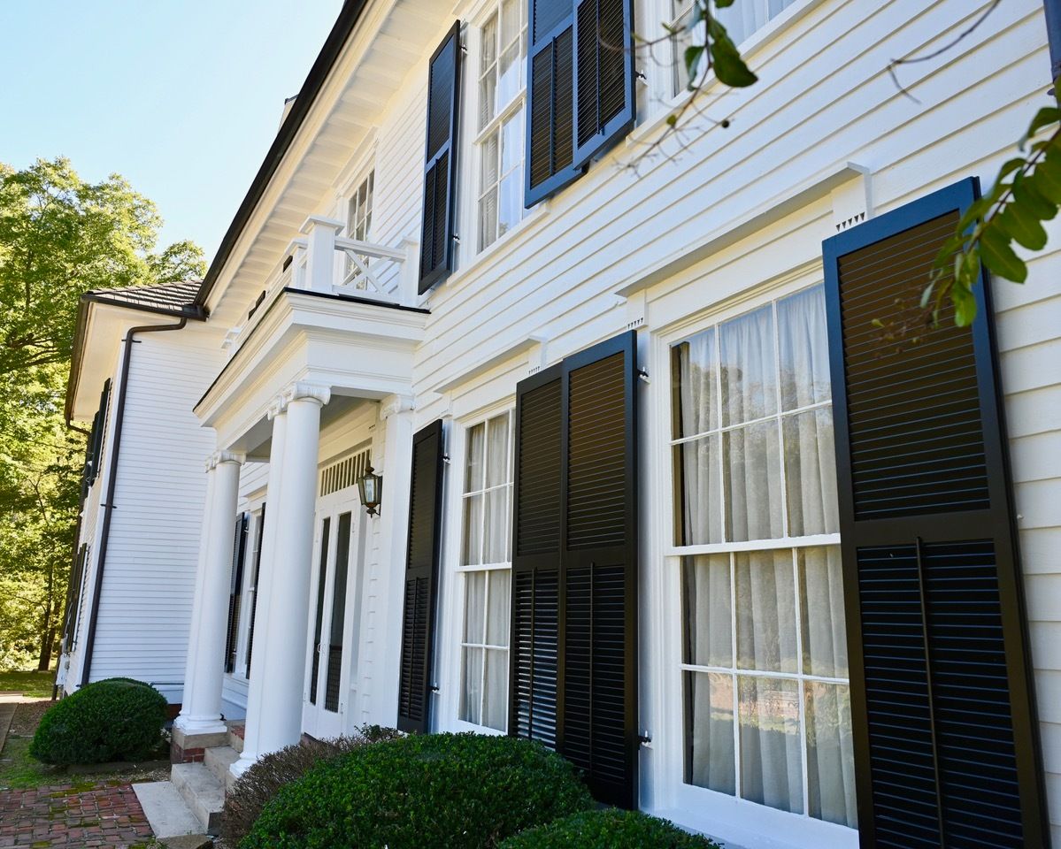A large white house with black shutters on the windows