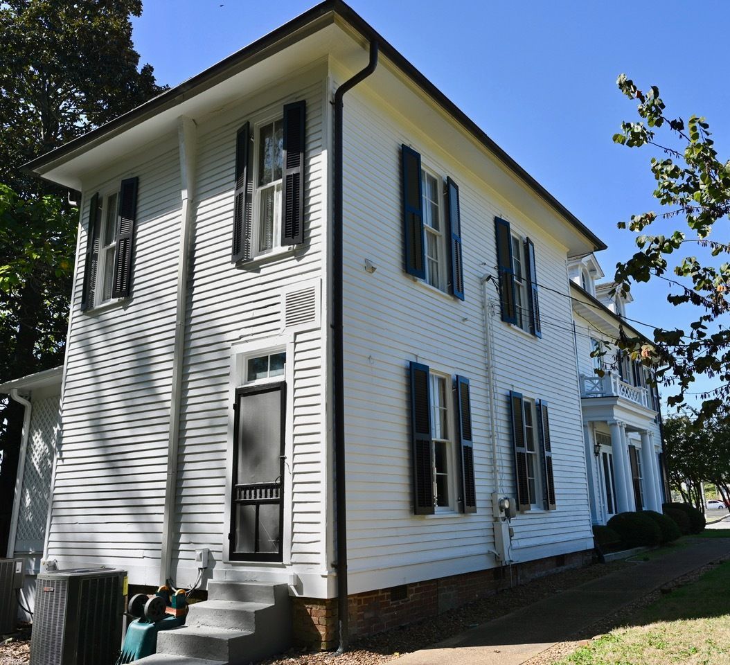 A large white house with black shutters on the windows