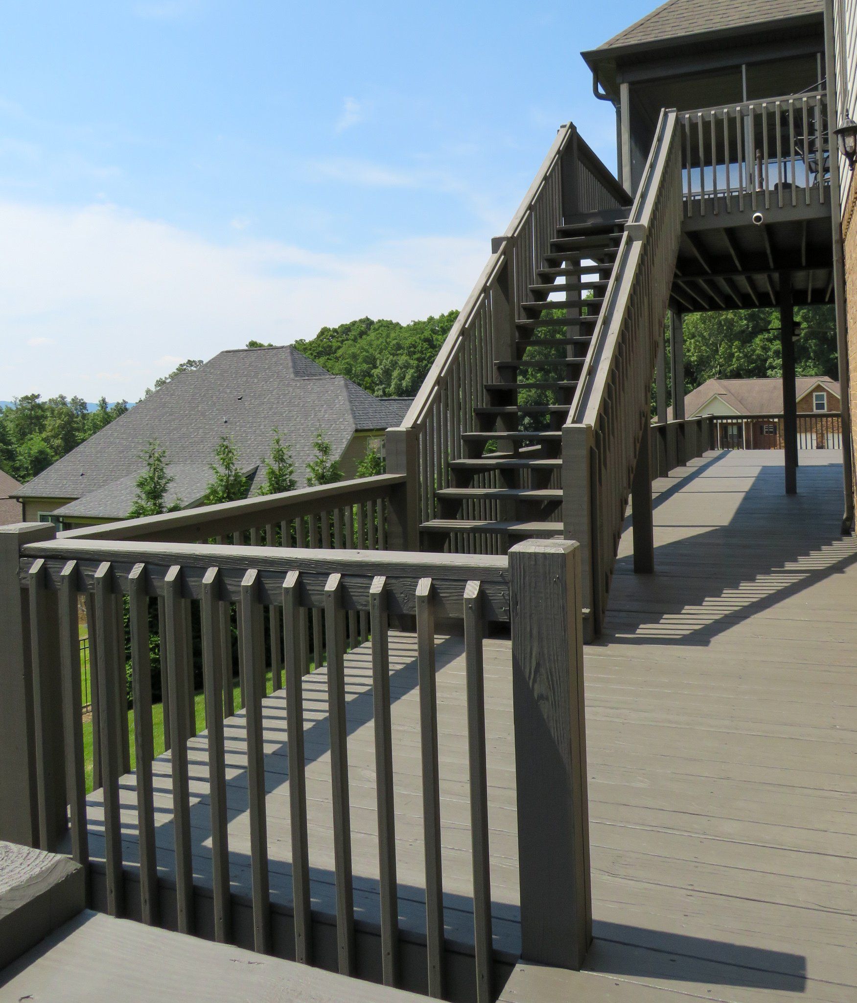 A wooden deck with stairs leading up to a house