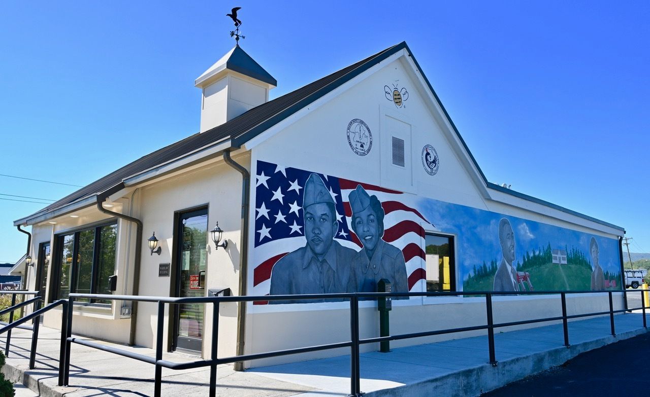 A white building with a mural on the side of it.
