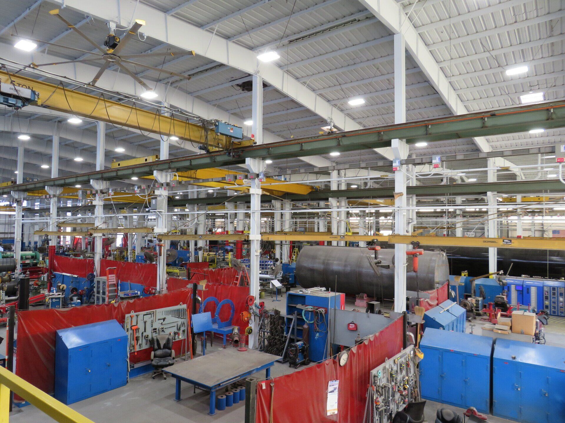 A large warehouse filled with lots of machinery and tables.