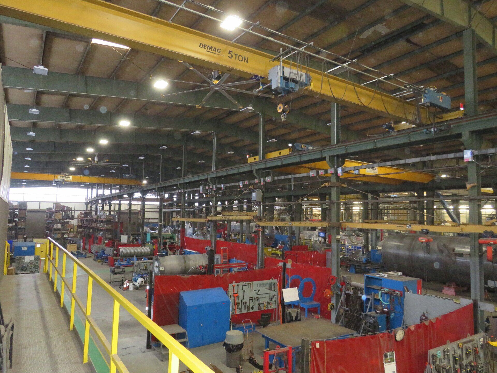 A large factory with a lot of machinery and a yellow railing