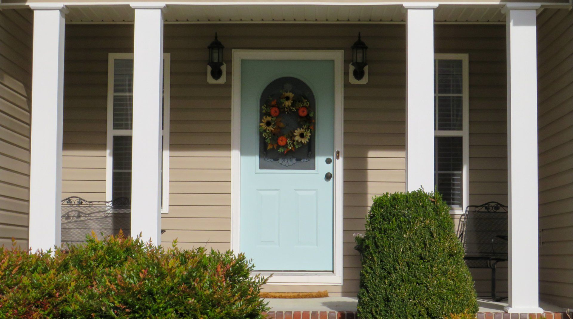 A house with a blue door and a wreath on it