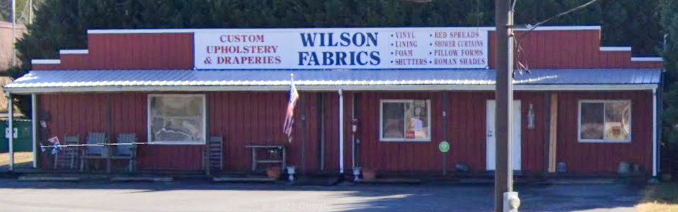 A red building with a sign that says wilson fabrics
