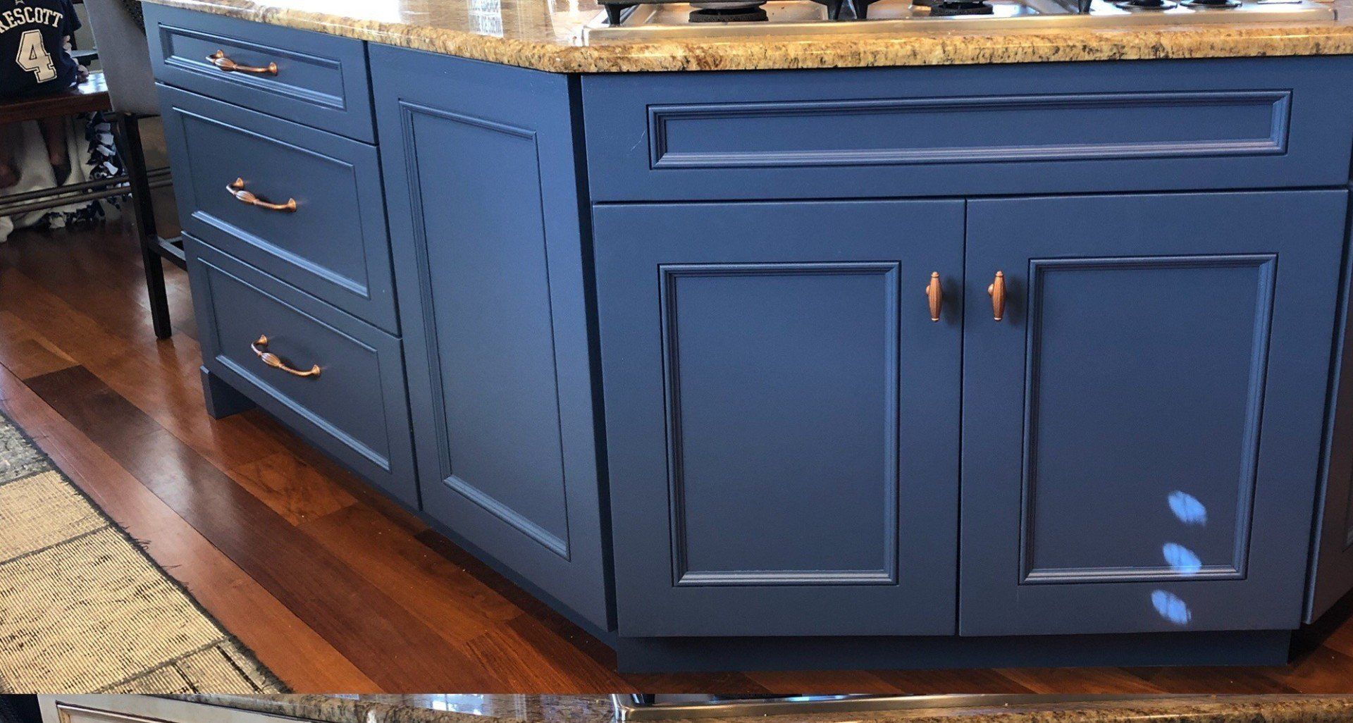 A kitchen with blue cabinets and a granite counter top.