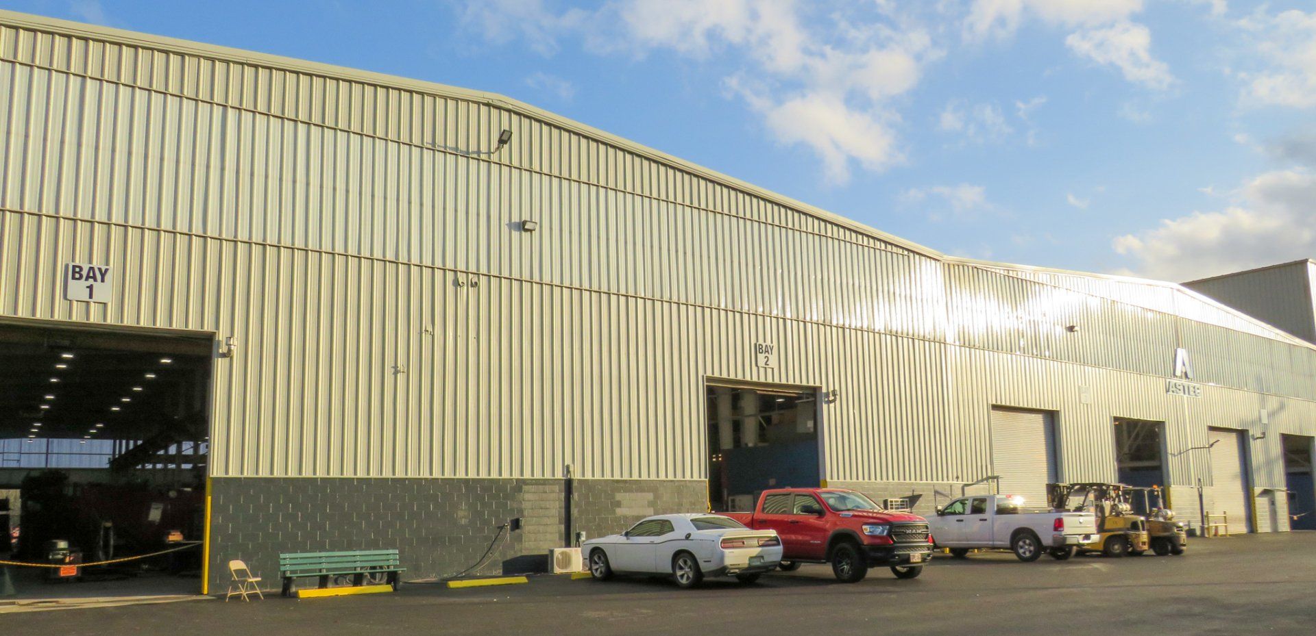 A row of cars are parked in front of a large building.
