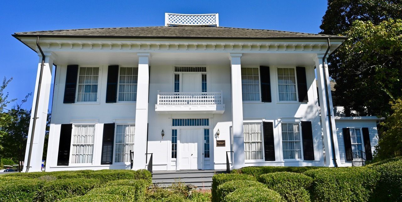 A large white house with black shutters on the windows