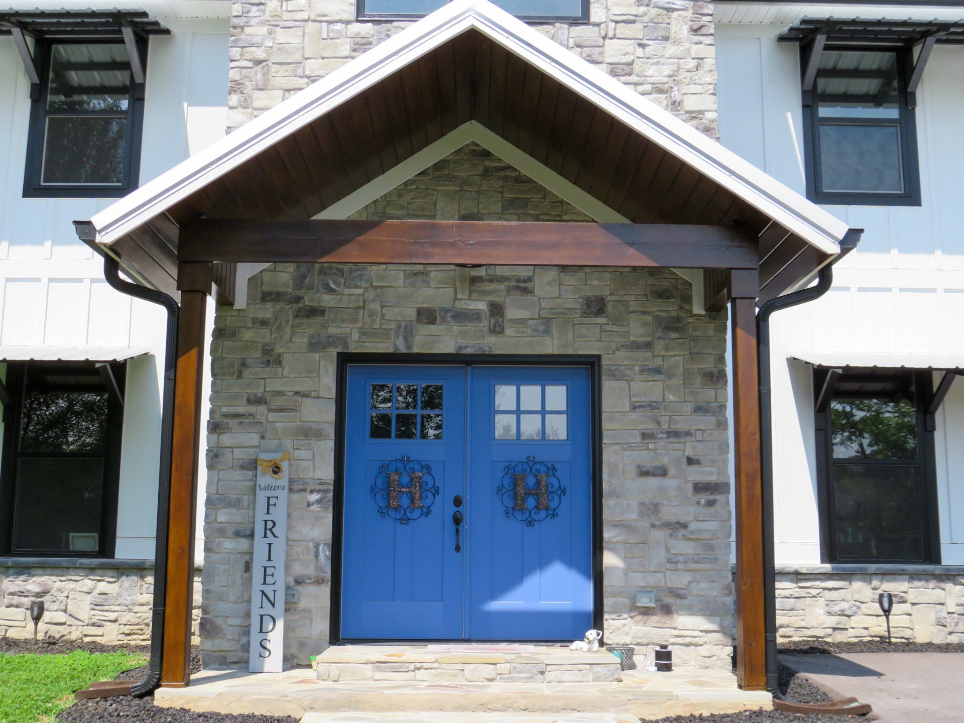 The front of a house with a blue door and a sign that says friends